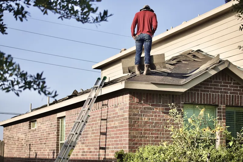 Professional roofer working on a residential roof in South Huntington